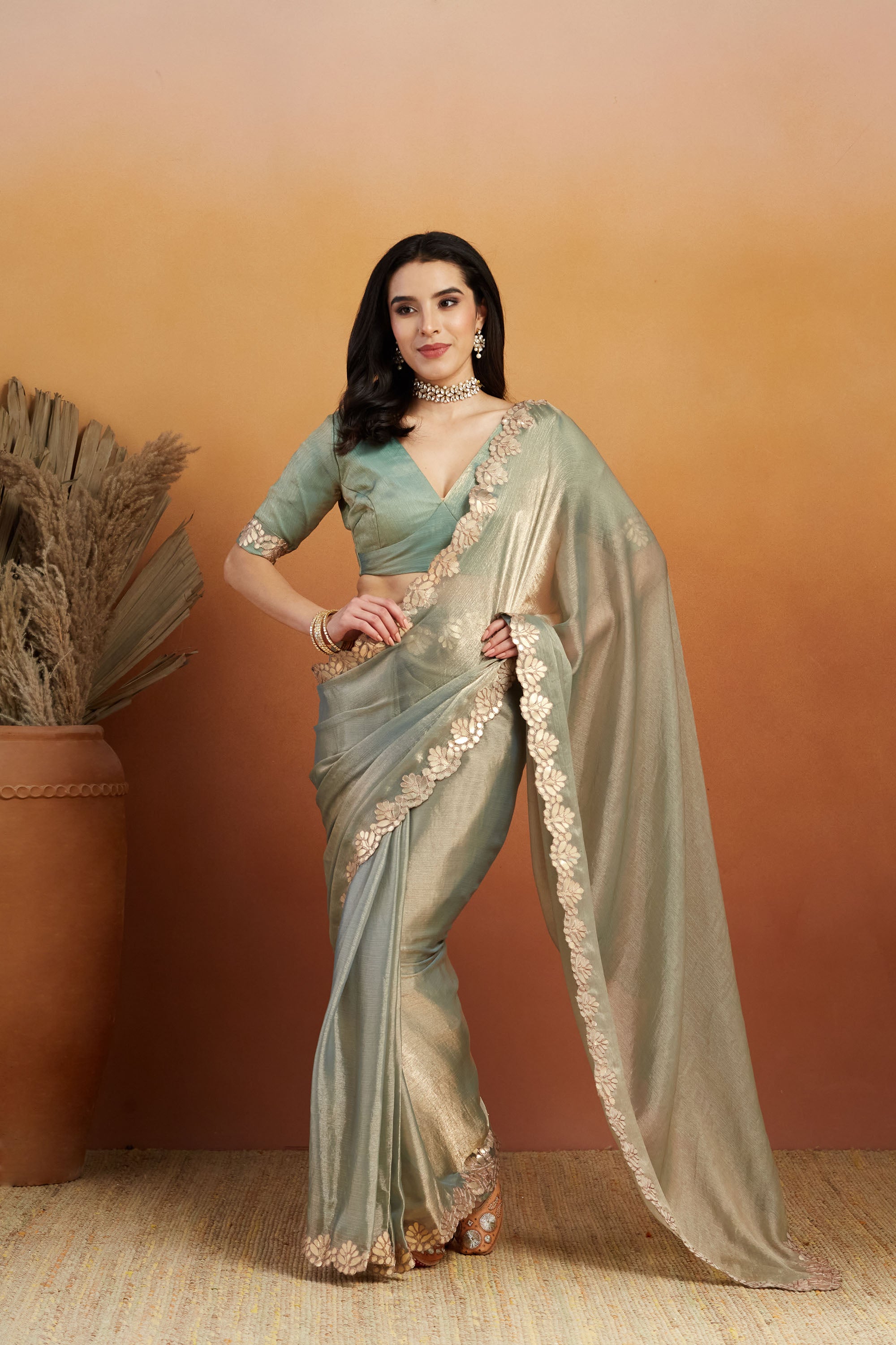 Highlights the muted green tone and the classic embroidered border.