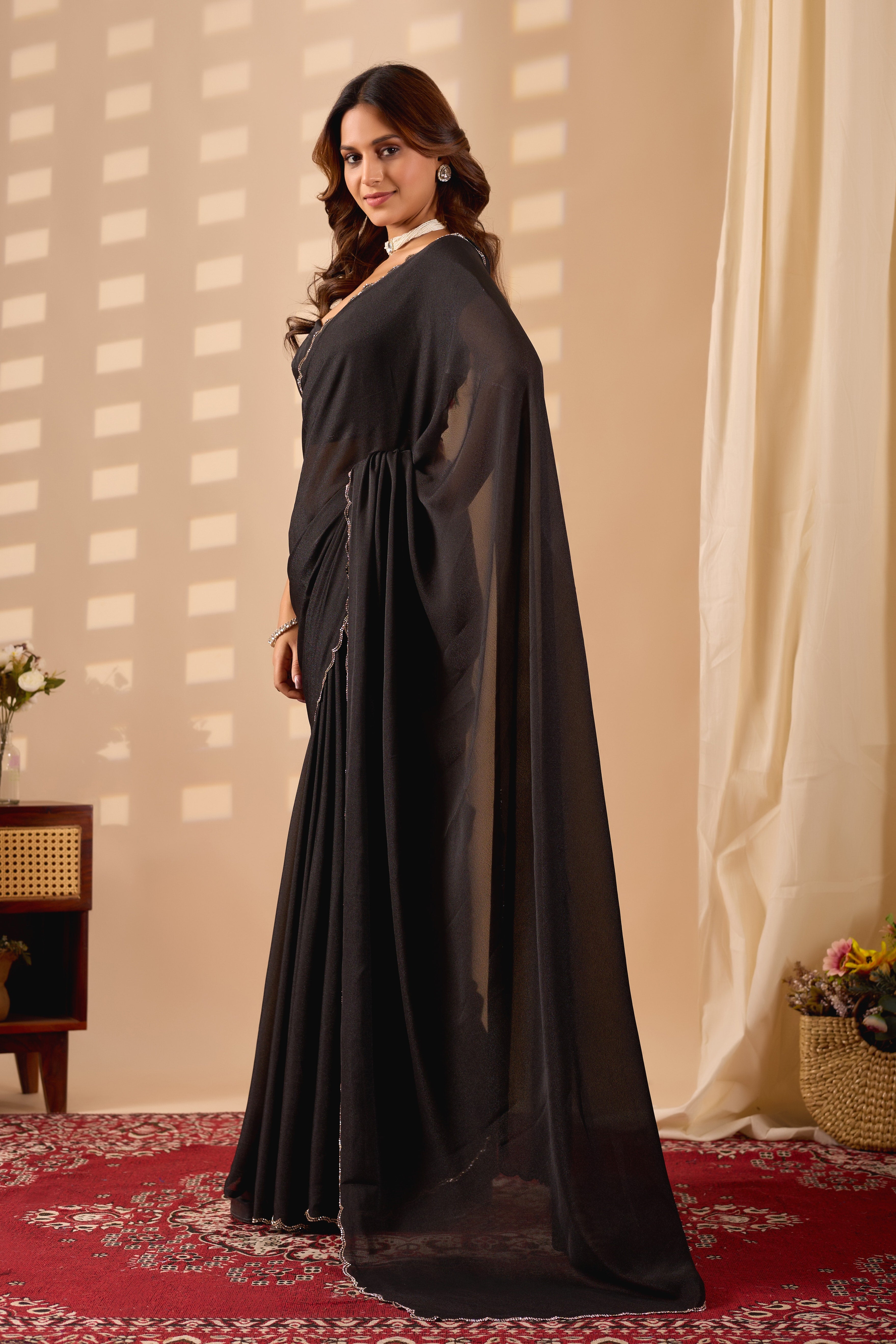 Elegant Black Poly Georgette saree featuring a shimmering texture and a delicate silver scalloped border for a sophisticated evening look.