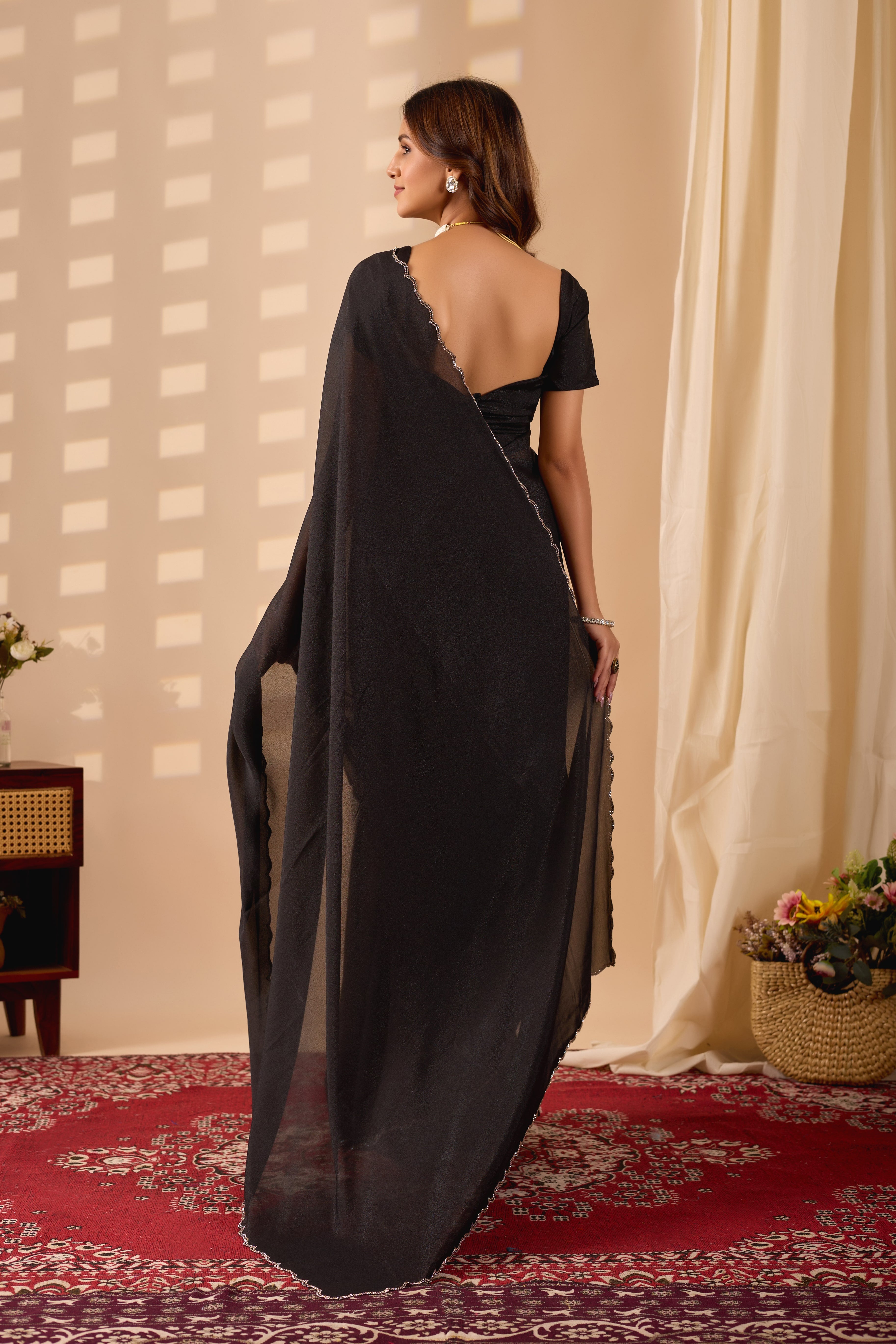 Elegant Black Poly Georgette saree featuring a shimmering texture and a delicate silver scalloped border for a sophisticated evening look.